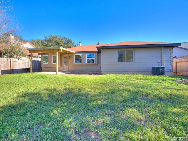 back of property with a yard, fence private yard, and central air condition unit