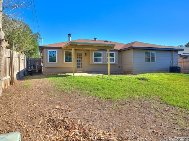 rear view of property with central AC, a lawn, a patio area, and a fenced backyard