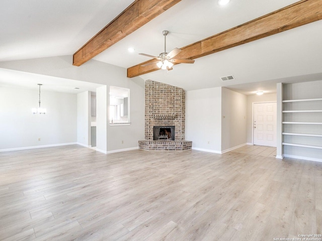 unfurnished living room featuring visible vents, lofted ceiling with beams, light wood-style flooring, a brick fireplace, and ceiling fan with notable chandelier