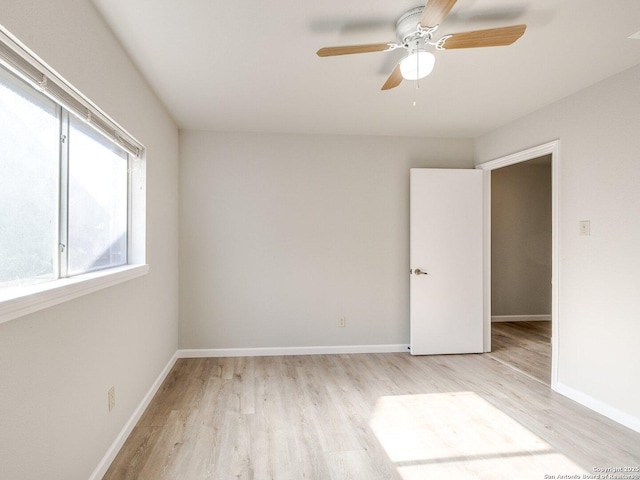 unfurnished room with light wood-type flooring, baseboards, and a ceiling fan