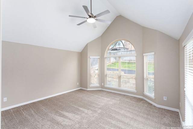 unfurnished room with high vaulted ceiling, light colored carpet, ceiling fan, and baseboards