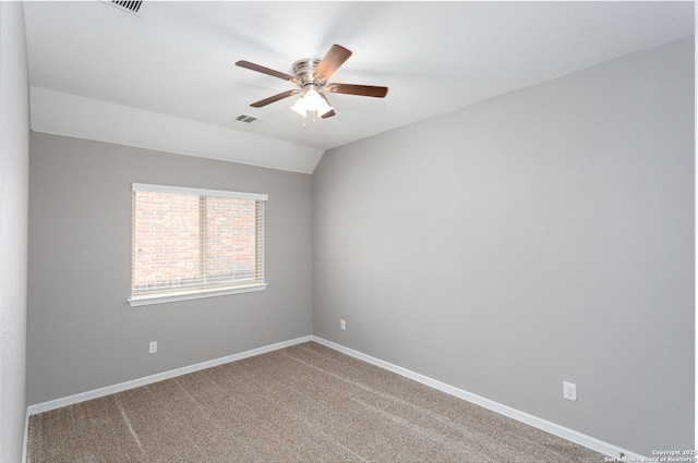 spare room with lofted ceiling, ceiling fan, visible vents, baseboards, and carpet