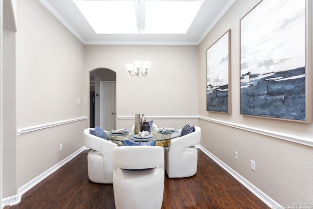 dining area featuring dark wood-style floors, baseboards, arched walkways, and crown molding