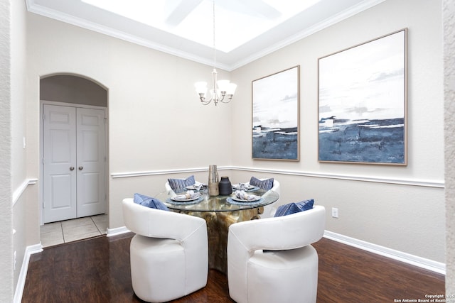 dining area featuring ornamental molding, arched walkways, and wood finished floors