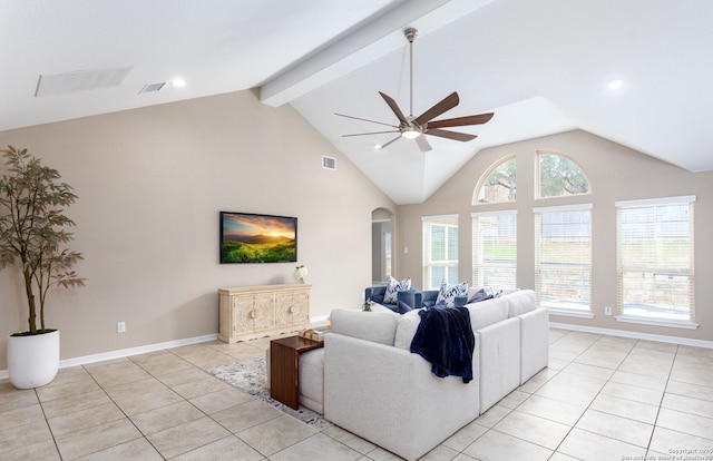 living room with light tile patterned floors, visible vents, arched walkways, and beamed ceiling