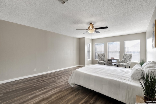 bedroom with visible vents, baseboards, a ceiling fan, dark wood-style flooring, and a textured ceiling