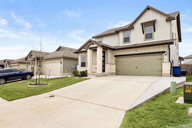 view of front of property featuring concrete driveway, central AC unit, board and batten siding, a front yard, and stone siding