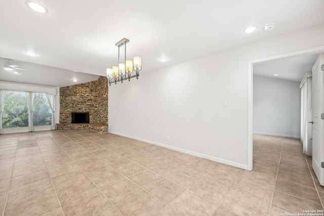 unfurnished living room with ceiling fan with notable chandelier, a fireplace, baseboards, and light tile patterned flooring