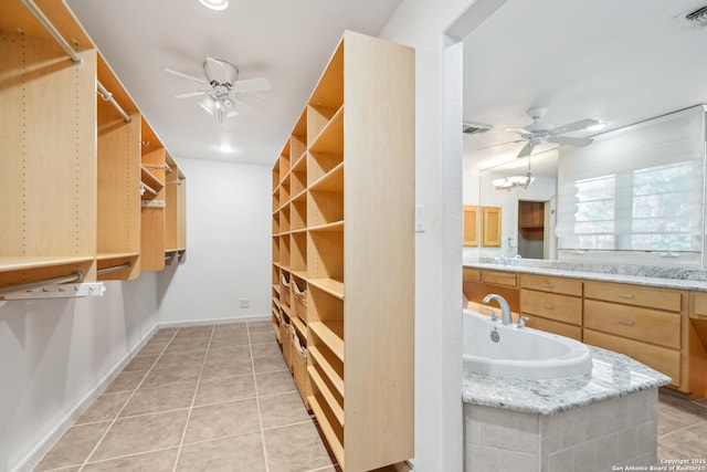 spacious closet with light tile patterned floors, visible vents, a sink, and a ceiling fan