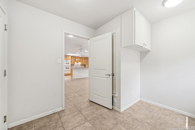 washroom featuring light tile patterned floors, baseboards, and a ceiling fan