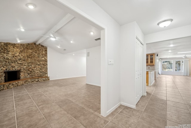 hallway with lofted ceiling with beams, light tile patterned flooring, visible vents, and baseboards