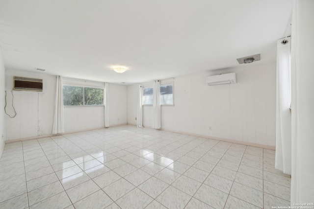 unfurnished room with light tile patterned floors, an AC wall unit, and a wall mounted AC