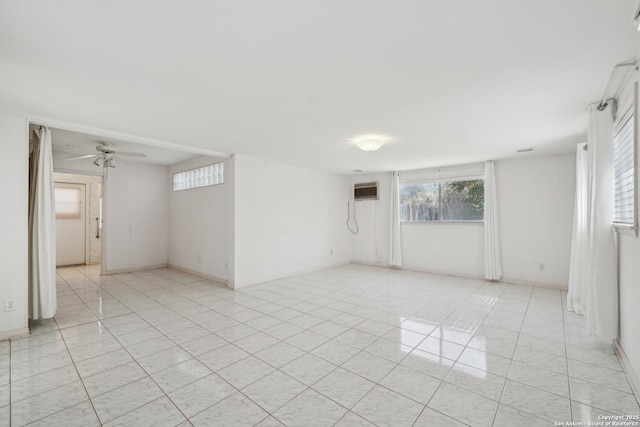 empty room with plenty of natural light, light tile patterned flooring, and a ceiling fan