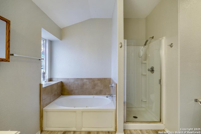 bathroom featuring lofted ceiling, a stall shower, and a bath