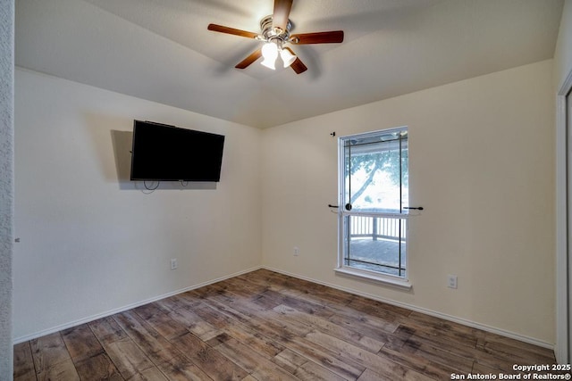 spare room featuring a ceiling fan, vaulted ceiling, baseboards, and wood finished floors