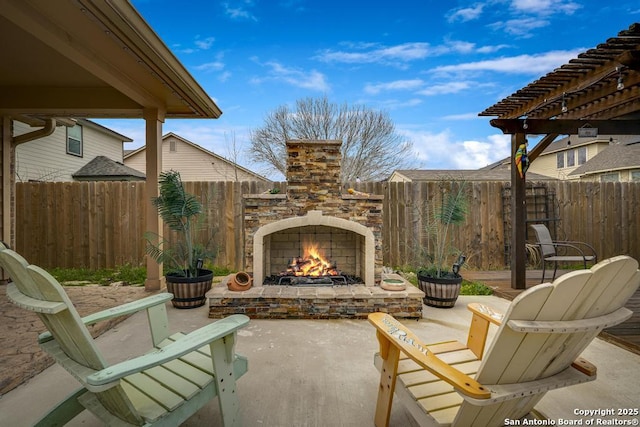 view of patio / terrace with an outdoor stone fireplace, a fenced backyard, and a pergola