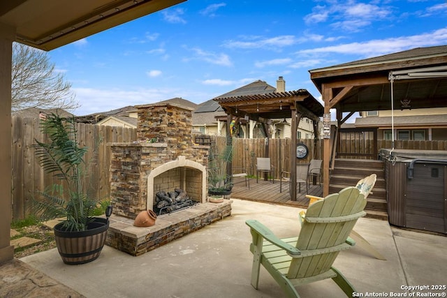 view of patio featuring an outdoor stone fireplace and a fenced backyard