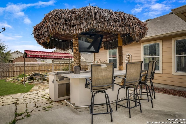 view of patio / terrace featuring fence and outdoor dry bar