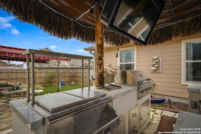 view of patio / terrace featuring area for grilling, fence, and an outdoor kitchen