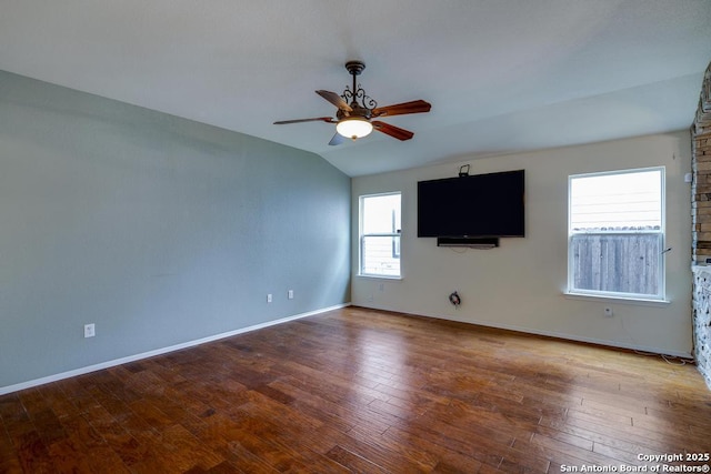 empty room with ceiling fan, baseboards, wood finished floors, and lofted ceiling