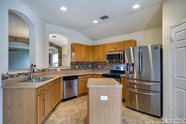 kitchen featuring stainless steel appliances, a sink, a kitchen island, visible vents, and light countertops