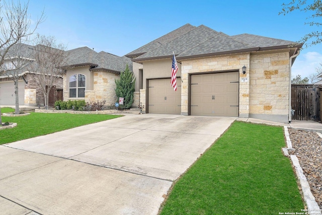 french country style house with an attached garage, concrete driveway, stone siding, roof with shingles, and a front yard