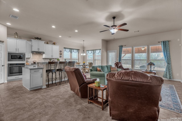 living area with ceiling fan, visible vents, and recessed lighting