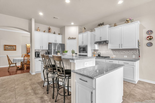 kitchen featuring a center island, visible vents, appliances with stainless steel finishes, white cabinetry, and under cabinet range hood