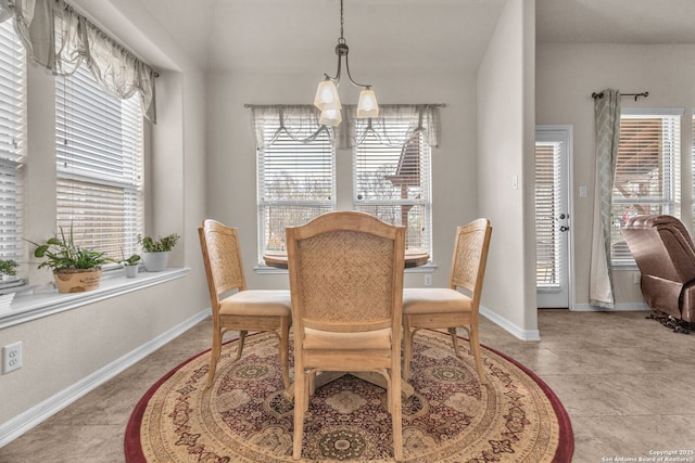 dining area with a wealth of natural light, baseboards, and a notable chandelier