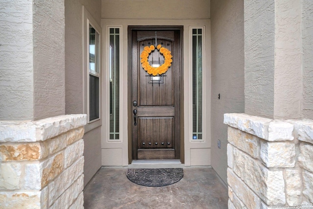 property entrance with stucco siding