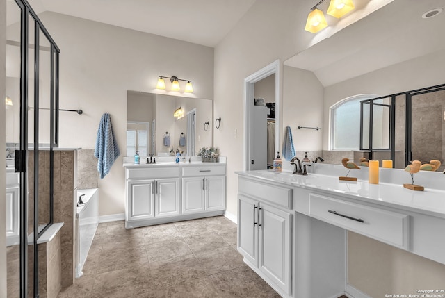 full bathroom featuring a garden tub, vanity, vaulted ceiling, a shower stall, and tile patterned floors