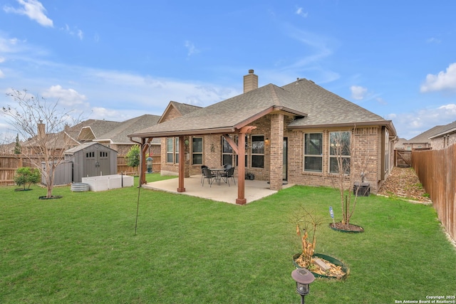 rear view of property with a fenced backyard, an outbuilding, a patio area, a shed, and brick siding