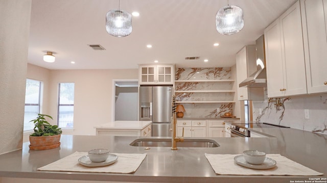 kitchen featuring glass insert cabinets, white cabinetry, stainless steel appliances, and pendant lighting