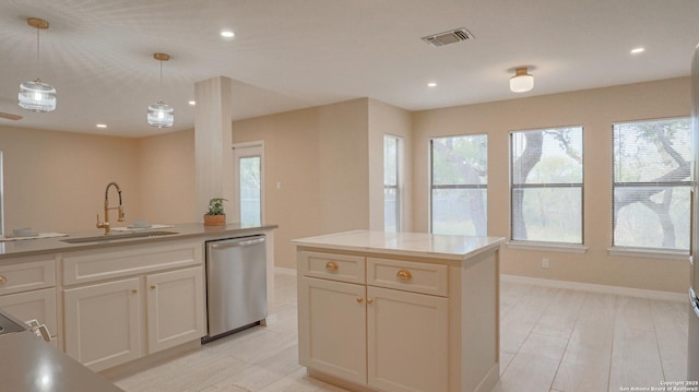 kitchen featuring visible vents, decorative light fixtures, light countertops, stainless steel dishwasher, and a sink