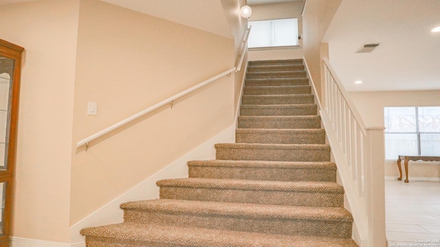 staircase with visible vents and recessed lighting