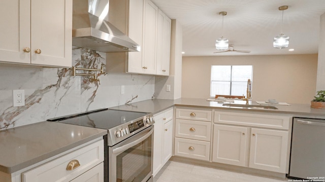 kitchen with wall chimney exhaust hood, stainless steel appliances, white cabinetry, pendant lighting, and a sink