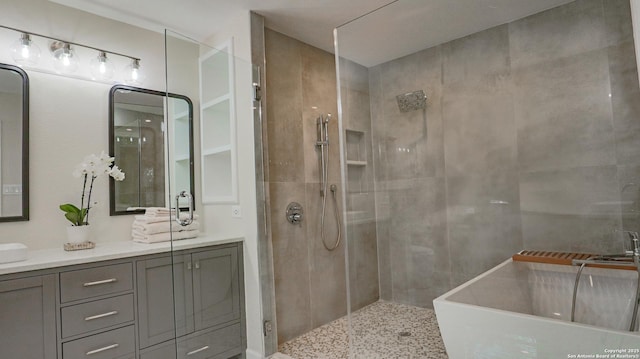 full bath featuring double vanity and a tile shower