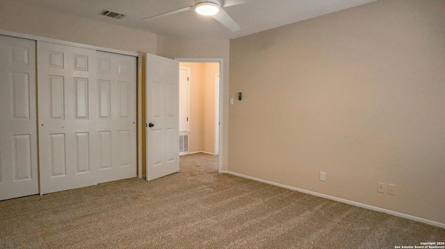 unfurnished bedroom featuring a closet, light colored carpet, visible vents, a ceiling fan, and baseboards