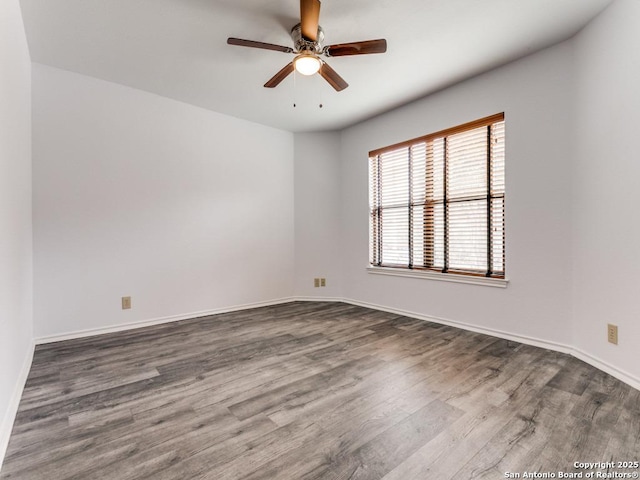 empty room featuring wood finished floors, a ceiling fan, and baseboards