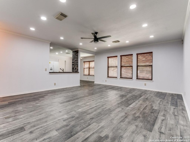 unfurnished living room with ornamental molding, visible vents, and ceiling fan