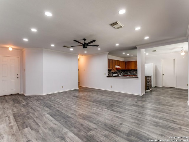 unfurnished living room featuring recessed lighting, wood finished floors, visible vents, a ceiling fan, and crown molding