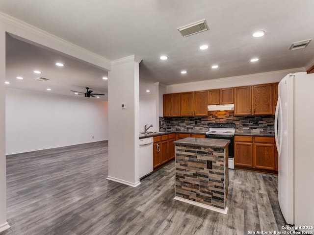 kitchen featuring dark countertops, white appliances, visible vents, and under cabinet range hood