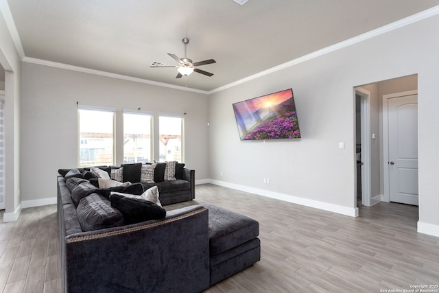 living room featuring crown molding, baseboards, ceiling fan, and wood finished floors