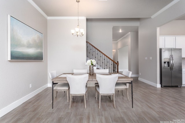 dining room featuring ornamental molding, light wood-type flooring, and baseboards