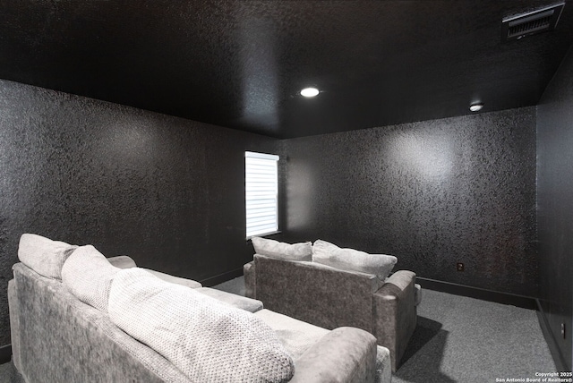 carpeted cinema room with visible vents and baseboards