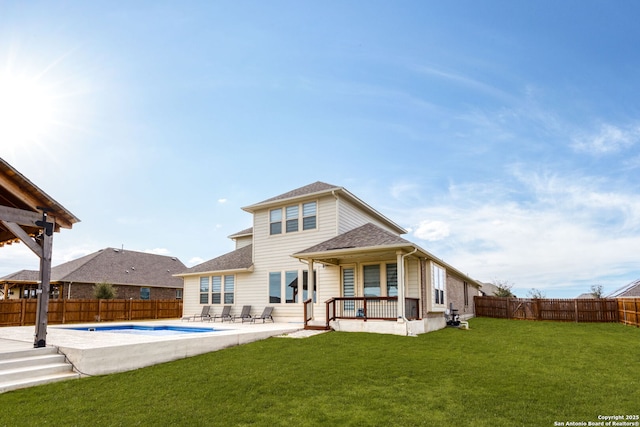 rear view of property featuring a fenced in pool, a patio area, a fenced backyard, and a yard