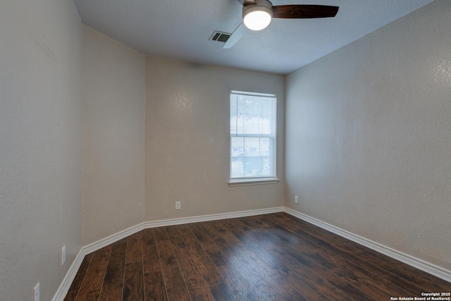 empty room featuring dark wood-style floors, visible vents, ceiling fan, and baseboards