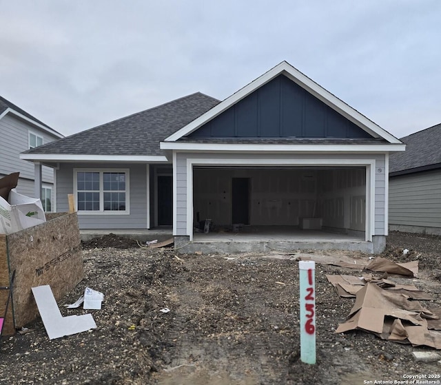 view of front of home featuring an attached garage, a shingled roof, and board and batten siding