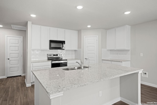 kitchen with black microwave, electric range, a kitchen island with sink, white cabinetry, and a sink