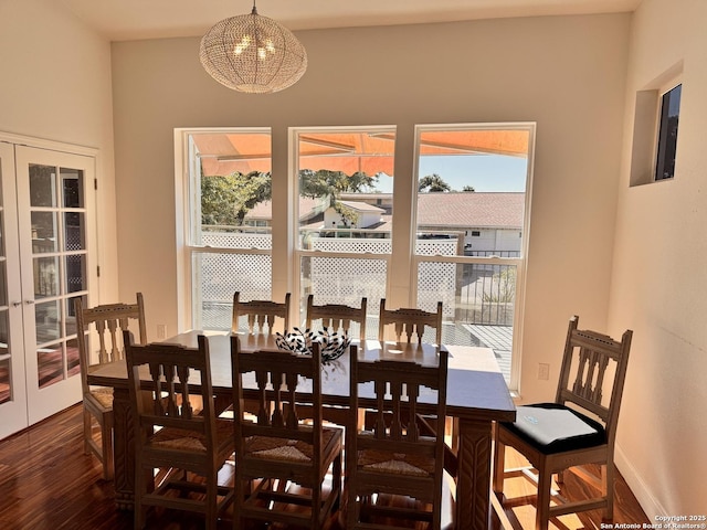 dining room with a chandelier, baseboards, and wood finished floors